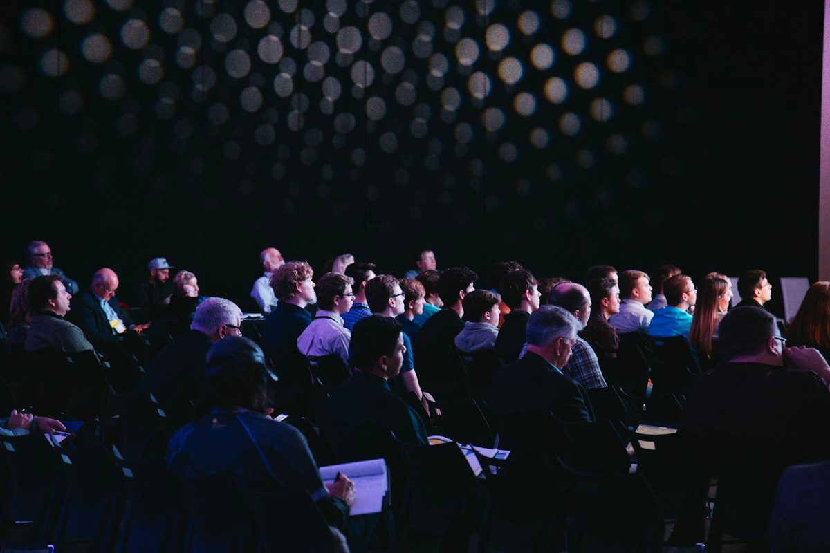 Audience watching a presentation in a dark hall